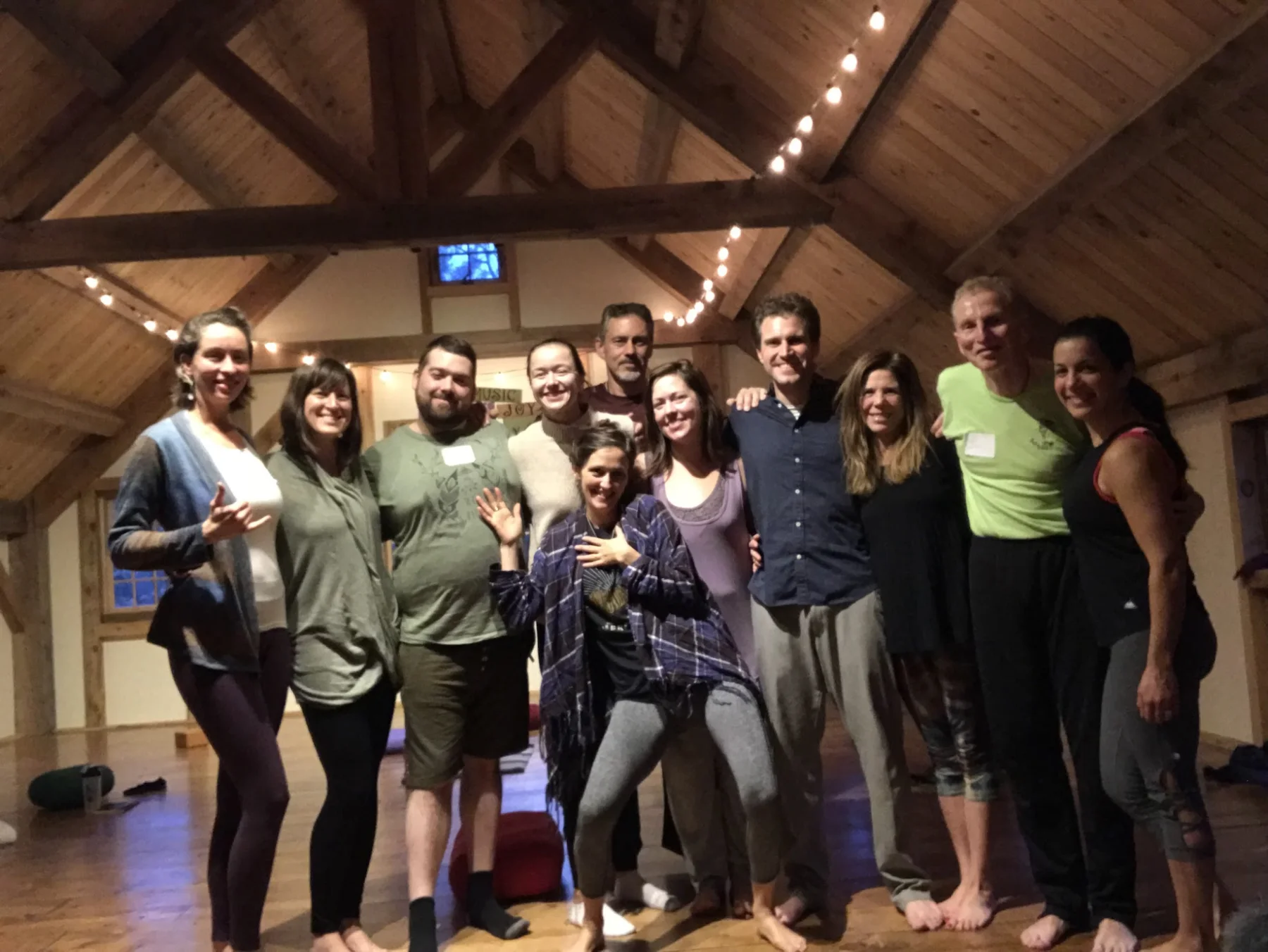 A HeartWise group standing together under the beams of a timber hall after a workshop